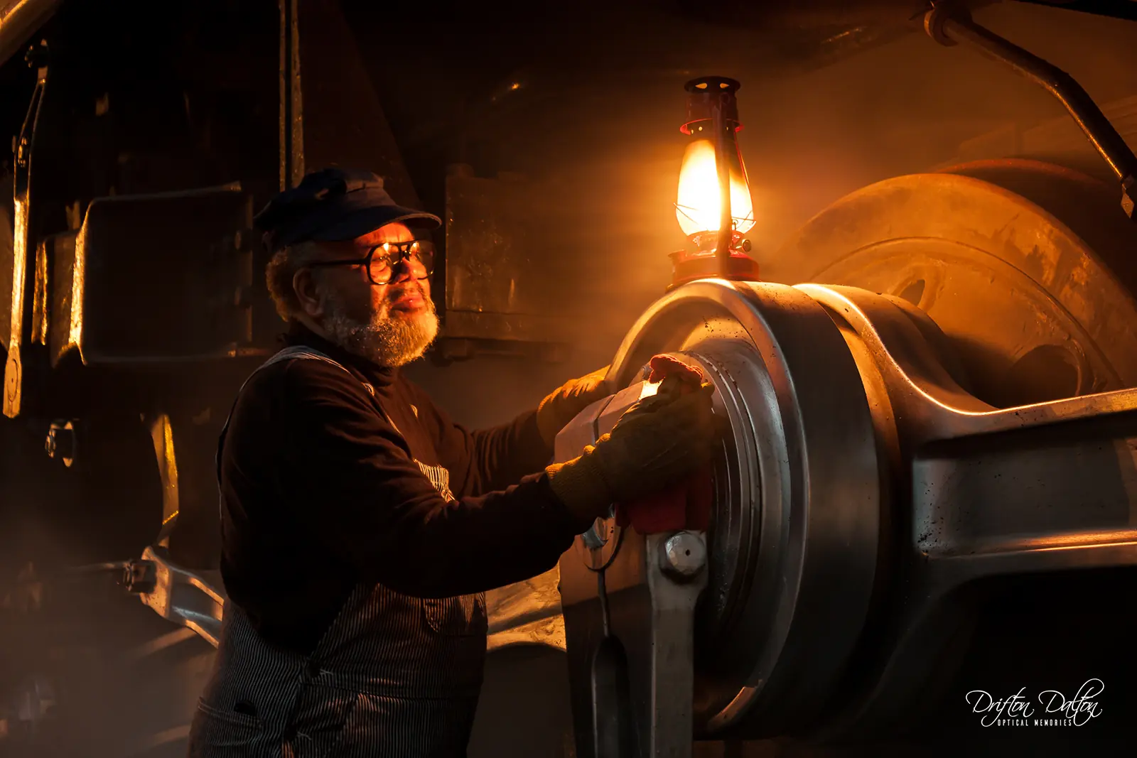 Staged train crew member inspecting Norfolk and Western 611 by lantern light