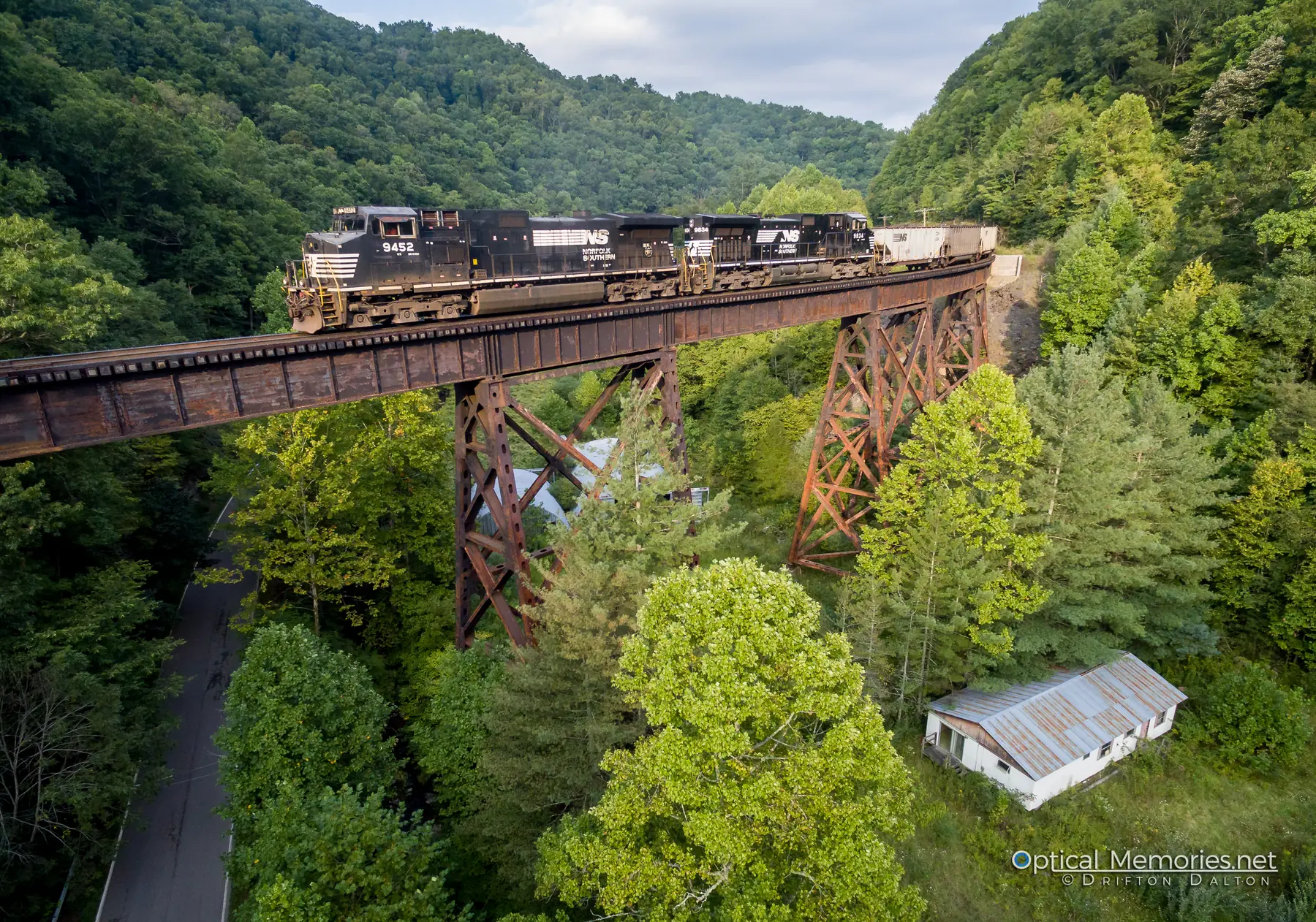Empty coal train crossing the Whitewood trestle above a mountain road